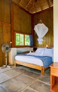 a bedroom with a bed with a fan and a desk at Casa Andalucia in San Juan del Sur