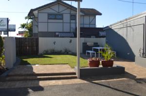 a backyard with a house with a fence at Best Western Bundaberg City Motor Inn in Bundaberg