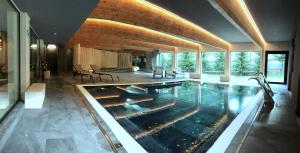 a house with a swimming pool in the middle of it at Parkhotel Fedora in Campitello di Fassa