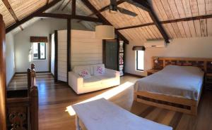 a bedroom with a bed and a couch in a room at La grange de G. in Grand Gaube +27 photos