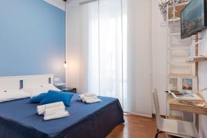 Un dormitorio con una cama azul con toallas. en B&B Monserrato en Nápoles