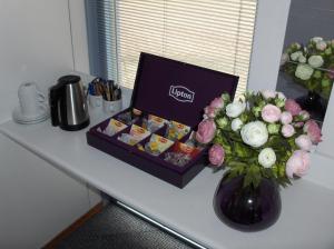 a table with a box of candy and a vase of flowers at B&B Zevenkamp in Rotterdam