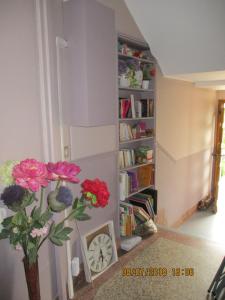 a room with a book shelf with flowers in a vase at Côté Marne in Champigny-sur-Marne
