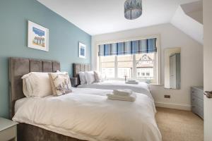 two beds in a room with a window at Alton House - The Annexe in Sheringham