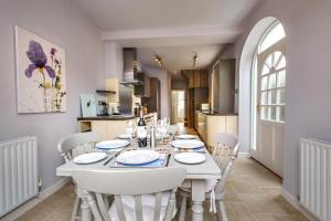 a white dining room with a white table and chairs at Alton House - The Annexe in Sheringham