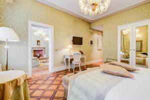 a bedroom with a bed and a table and a dining room at Hotel Al Duca Di Venezia in Venice