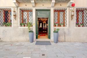 dois grandes vasos azuis na frente de uma porta em Hotel Al Duca Di Venezia em Veneza