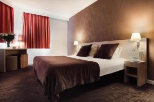 アンティーブにあるHôtel de l'Étoileの大きなベッドと赤いカーテンが備わるホテルルームです。