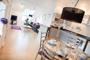 a kitchen and living room with a table and chairs at Regent House deluxe 2 bedroom apartment in Harrogate