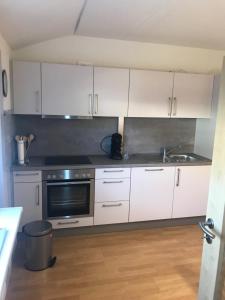 a kitchen with white cabinets and a sink at Ferienhaus "Am Stauwerk" in Engelskirchen