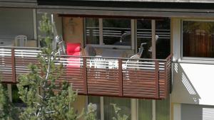 un balcón con barandilla de madera en una casa en Quellenhof D04, en Davos