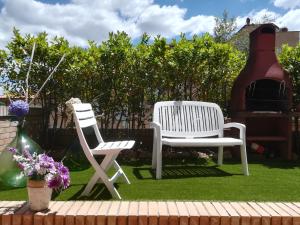 dos sillas blancas sentadas en el césped en un patio en Casa Arcobaleno, en Siena