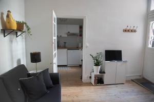 a living room with a couch and a kitchen at L'authentique - Coeur de ville in Toulouse