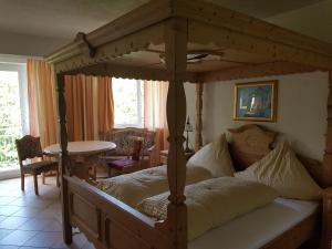 a bedroom with a wooden canopy bed with a table at Hotel Zur Engelsburg in Hausen-Wied +53 photos