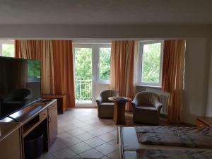 a living room with two chairs and a large window at Hotel Zur Engelsburg in Hausen-Wied