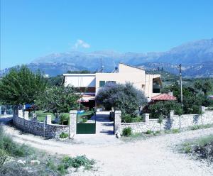 a building with a fence in front of it at Agrotourism Himara in Himare