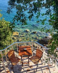 a table and two chairs on a balcony overlooking the ocean at Apartman Ail 2 in Ulcinj