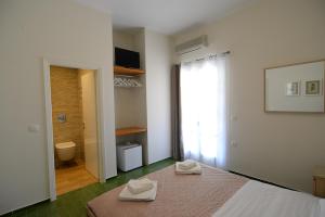 Villa Anesis في سبيتسيس: غرفة نوم عليها سرير وفوط