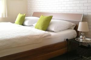 Bett mit weißer Bettwäsche und gelben Kissen in der Unterkunft Ferienwohnungen Gala in Bad Kissingen