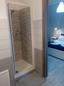 a walk in shower in a room with a bedroom at B&B Zu Tanu e Za Carmela in Realmonte