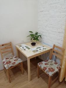 a wooden table with two chairs and a plant on it at Tihiy dvorik in Saint Petersburg