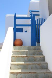 una rampa di scale con un cancello blu e una pentola di Mare Blue Ios a Ios Chora Altre 12 foto