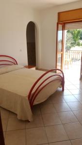 a bedroom with a bed with a view of a patio at Residence Oasi in Briatico