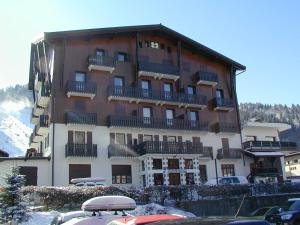 a large building with balconies and cars parked in front of it at Edelweiss in Morzine