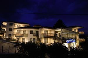 a large white building with a sign in front of it at Artemis Plaza in Agia Paraskevi