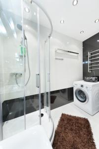 a bathroom with a shower and a washing machine at Alex Аpartments in Minsk