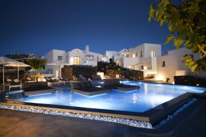 a swimming pool in front of a villa at night at Nova Luxury Suites in Pyrgos