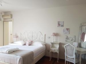 una camera bianca con letto bianco e scrivania di Villa Montenero a Cavalcaselle