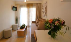 a living room with a couch and a table with flowers at Artemis Plaza in Agia Paraskevi