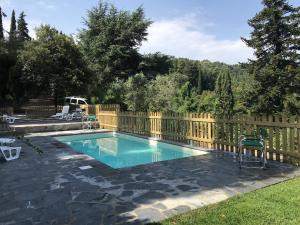 a swimming pool in a yard with a wooden fence at B&B La Casa di Alice in Camaiore