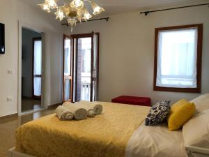 a bedroom with a large bed with towels on it at Grazia's Apartment in Chioggia