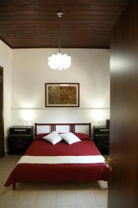 フォンターネ・ビアンケにあるVilla Giuliaのベッドルーム1室(大型赤いベッド1台、枕2つ付)