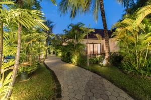 a path leading to a house with palm trees at Palace Residence & Villa Siem Reap in Siem Reap