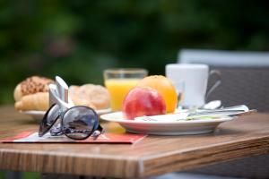 ein Tisch mit einem Teller Obst und einem Glas Orangensaft in der Unterkunft Hotel Edenpark in Brunssum + 27 Fotos