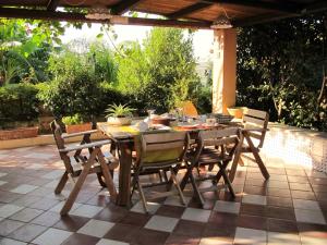 マリーナ・ディ・ラグーザにあるVilla Spadolaの木製テーブルと椅子付きのパティオ