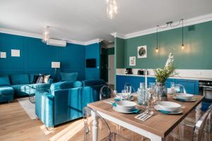 - un salon avec des murs bleus, une table et des chaises dans l'établissement District17 - LoftAffair Collection, à Cracovie