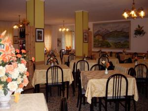 a restaurant with tables and chairs with flowers on them at Albergo Ristorante Pace in Bognanco