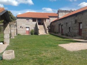 un antiguo edificio de piedra con un patio de césped en Quinta da Fonte Arcada en Paço de Sousa