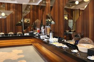 a restaurant with a counter with food on it at 7 Apple Resort, Lonavala in Lonavala