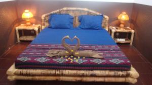 a bedroom with a bed with a bedspread with two hearts at Relaxing Homestay in Kuta Lombok