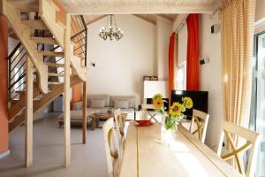 a living room with a dining room table with flowers on it at Villa Niriides in Lefkada Town