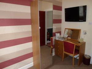 a room with a desk and a tv on a striped wall at The Broughton Hotel in Edinburgh