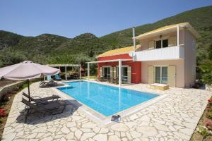 a villa with a swimming pool in front of a house at Villa Niriides in Lefkada Town