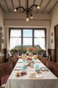 una sala da pranzo con tavolo e una grande finestra di Residenza Fabroni a Montepulciano