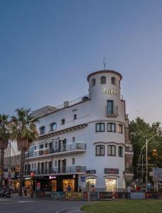 un gran edificio blanco con un cartel. en Cliper Apartments by Escampa Hotels, en Platja d'Aro