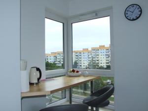 a kitchen with a table and two chairs and a clock at Apartament nad morzem, Gdańsk Zaspa in Gdańsk